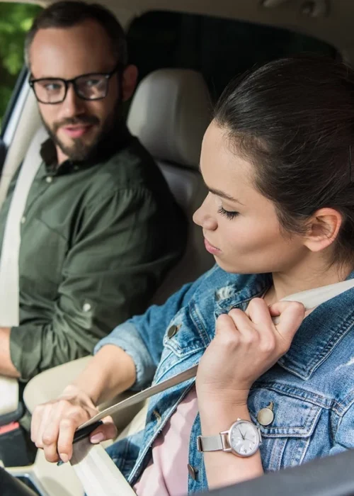 student-fastening-seat-belt-in-car-during-driving-test
